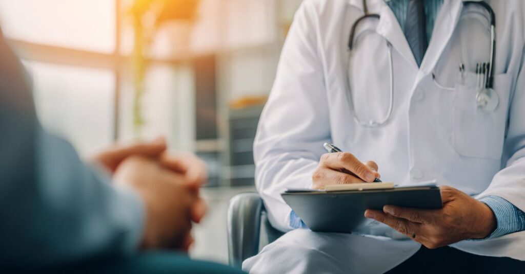 Doctors Consultation Writing on Patient Chart – ACO REACH Care Coordination | ASAAR Medical Two doctors in consultation writing on a patient chart as part of the ACO REACH care coordination model at ASAAR Medical.