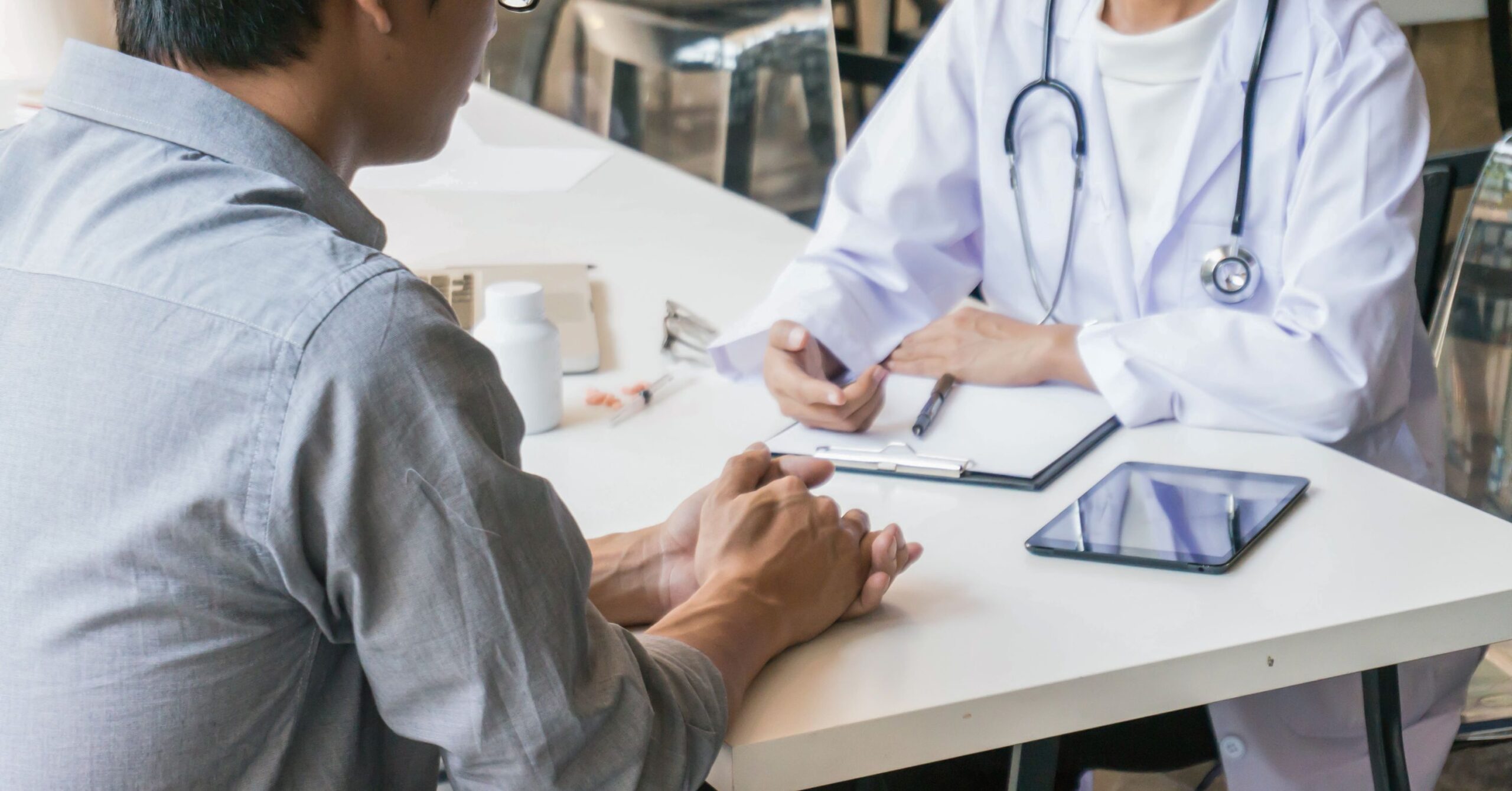 One-on-One Care Management Consultation | ASAAR Medical A healthcare provider in a white lab coat sitting across from a patient at a desk, discussing health goals during a care management session.